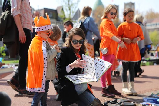 Gezellige Koningsdagdrukte met muziek, terrassen en feestgangers in de binnenstad van Leiden