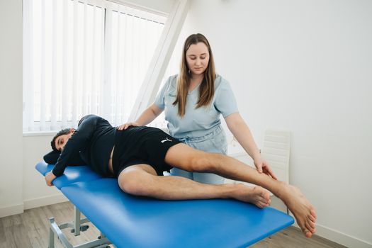 Sport fysiotherapie Leiden met sporter die knie-oefeningen doet in een behandelruimte na training